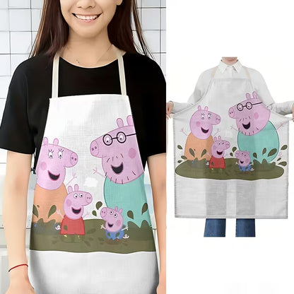 Egy mosolygós nő szemből fotózva, rajta a saras pocsolyában ugráló Peppa Malac családot ábrázoló konyhai kötény.