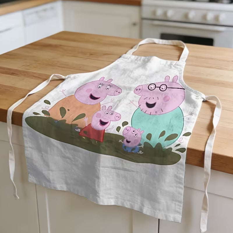 A Peppa Malac mintás megerősített vászon kötény teljes hosszában kiterítve egy fa konyhaszigeten.